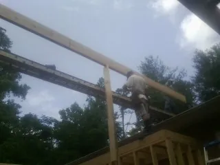 Carpenter setting a ridge beam over a new addition frame — Ice Dam Removal by Roofing Brothers in Battle Creek