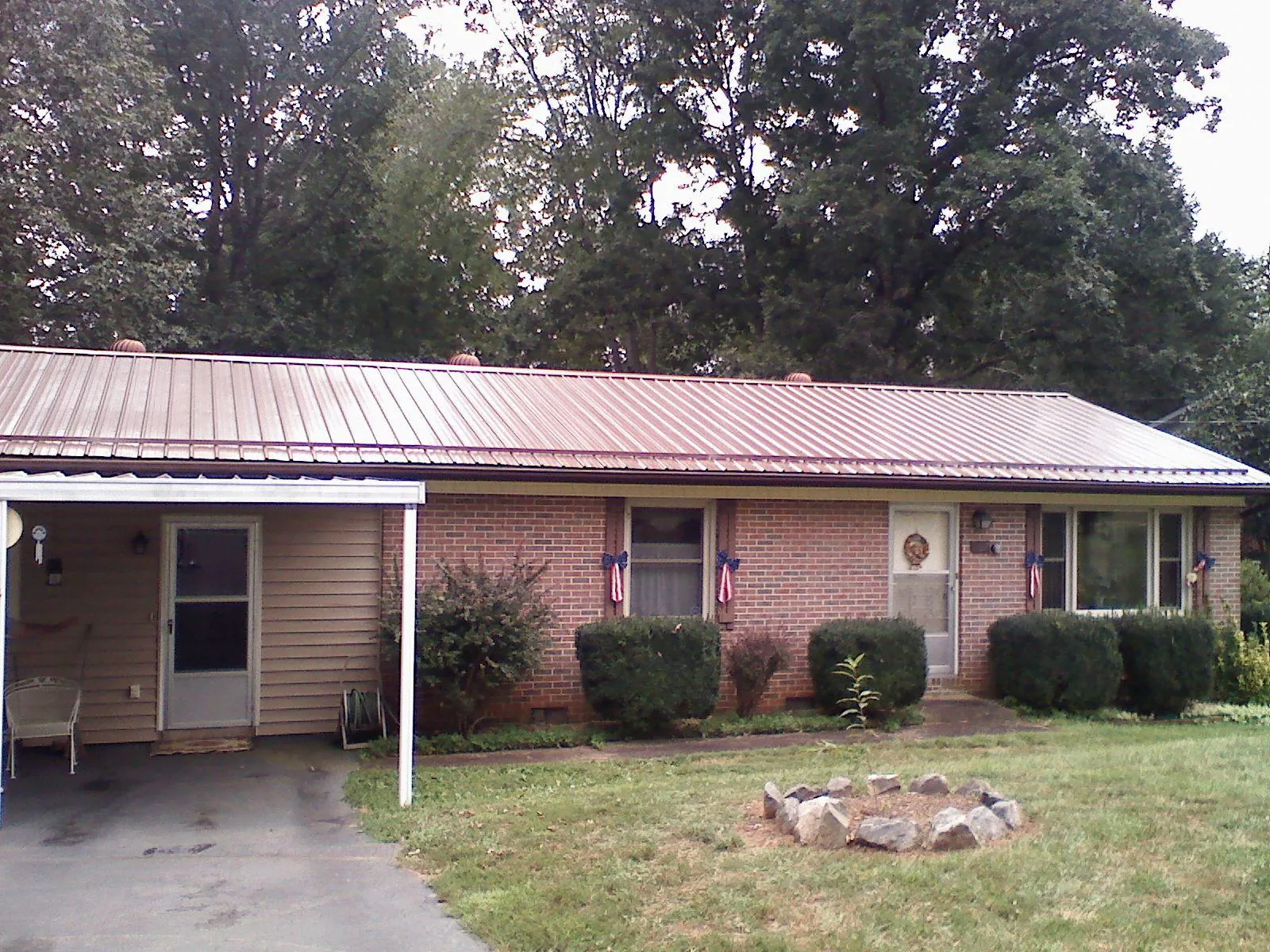 Bronze metal roof and carport on a brick ranch home — Roof Repair work by our crew in Battle Creek