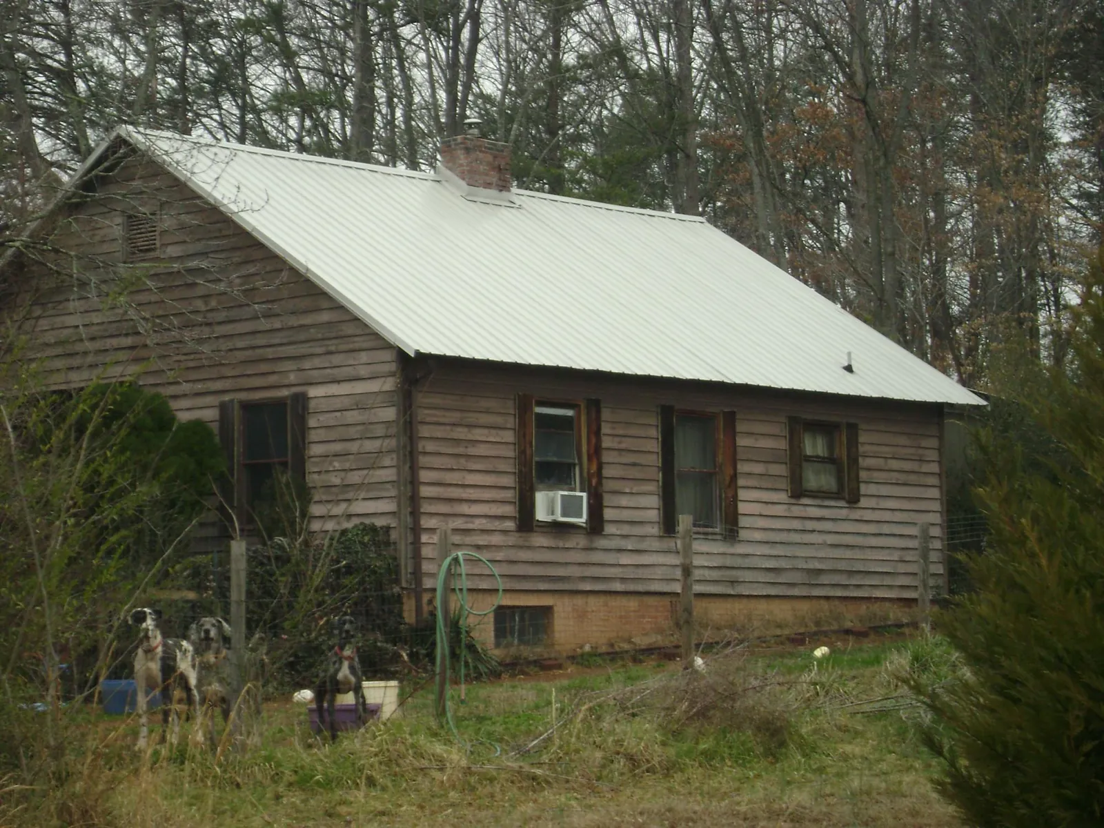 White metal roof on an old wood sided farmhouse, from a Metal Roof Installation job in Battle Creek